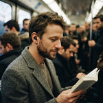 Homme lisant dans le métro avec un bouchon d'oreille Quiet Social noir