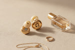 Bouchons d'oreilles QUIET Quiet Adapte dorés avec embouts en silicone sur une surface texturée beige